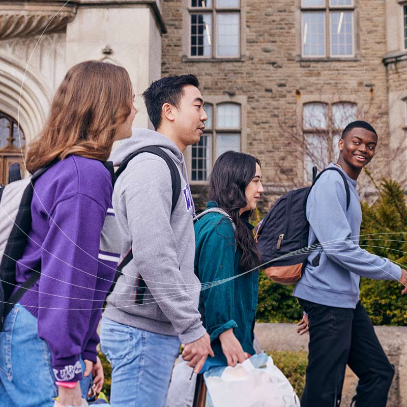 3 student passing through University College Tower