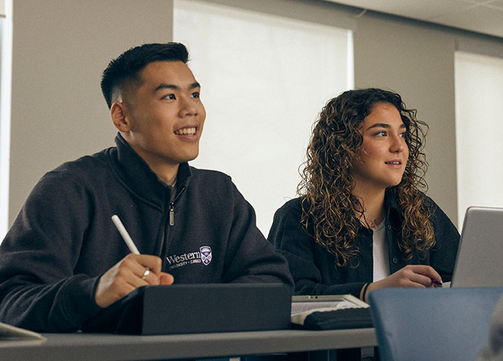 Two student sitting down and paying attention in class