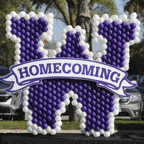 Western's purple and white balloons decorated in the shape of a W with banner reading Homecoming