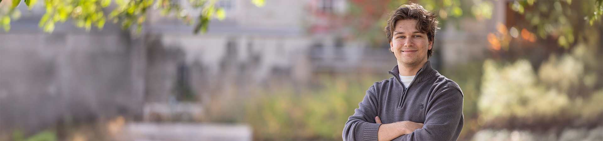 Person smiling outdoors while sitting on steps