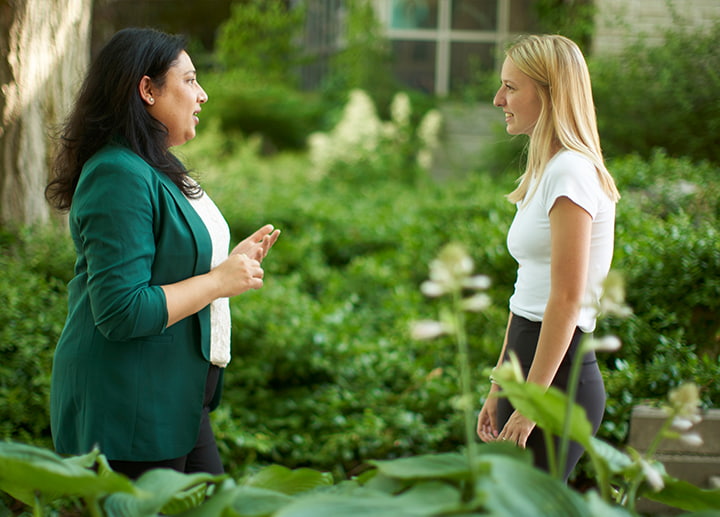 Two people talking in a garden