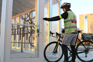 Cyclist entering bike shelter with bike