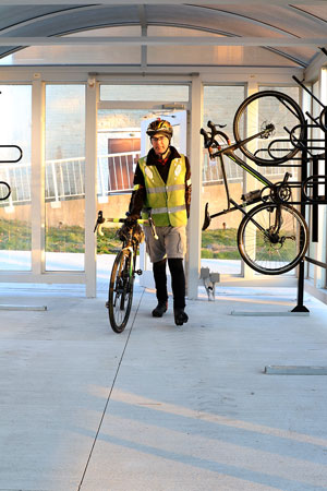 Cyclist walking with bike in bike shelter