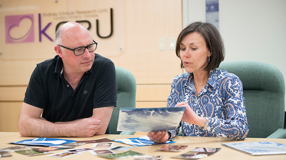 Dr. McIntrye and Cindy House looking at photos on table