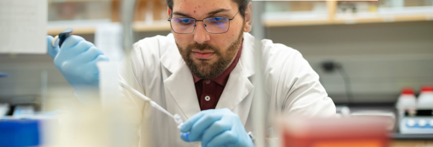 Researcher using a pipette at a lab bench