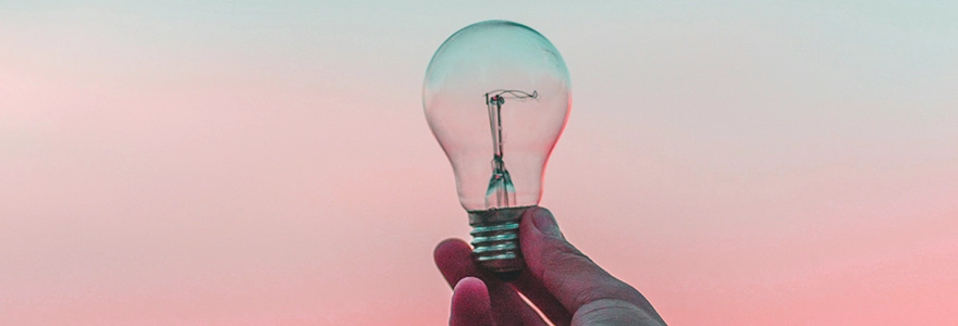 A hand holding a lightbulb