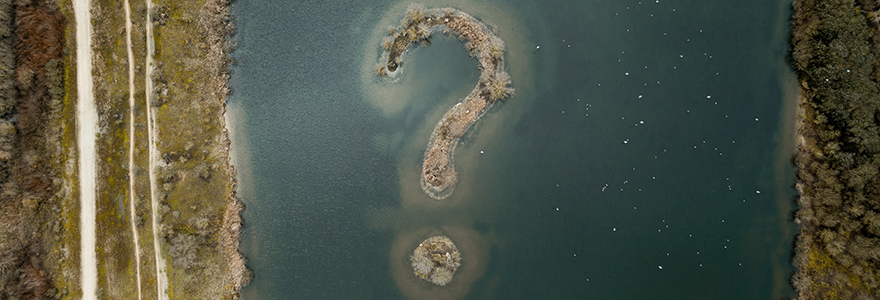 Decorative image of a two islands, shot from overhead, that form a question mark in the water.