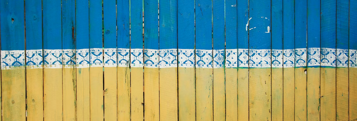 Wooden fence painted in the colours of the Ukrainian Flag