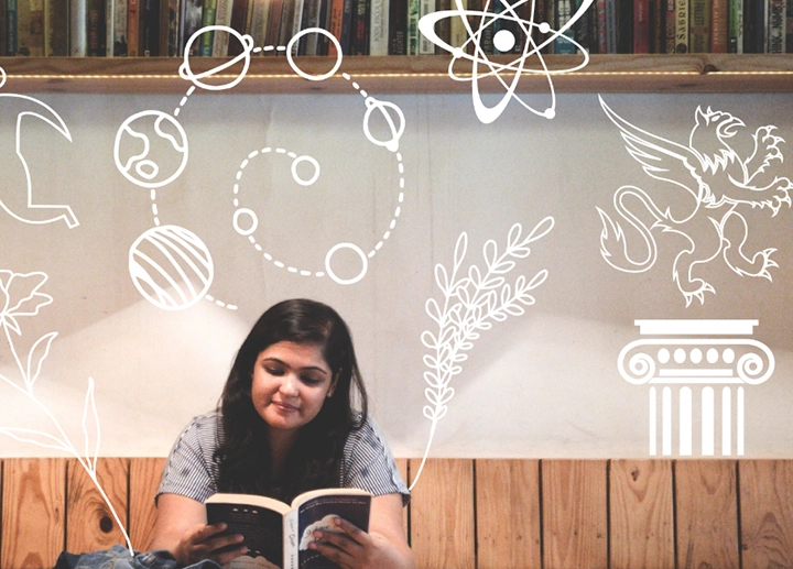 Woman sitting at a table with various glyphs and images floating above her