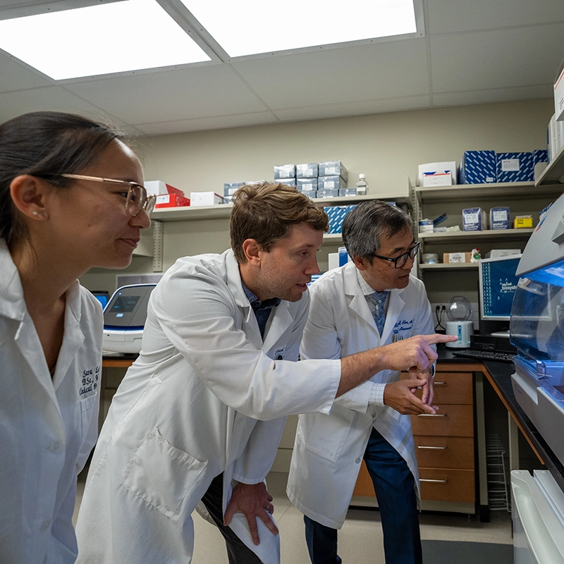 Richard Kim works with graduate students during an experiment