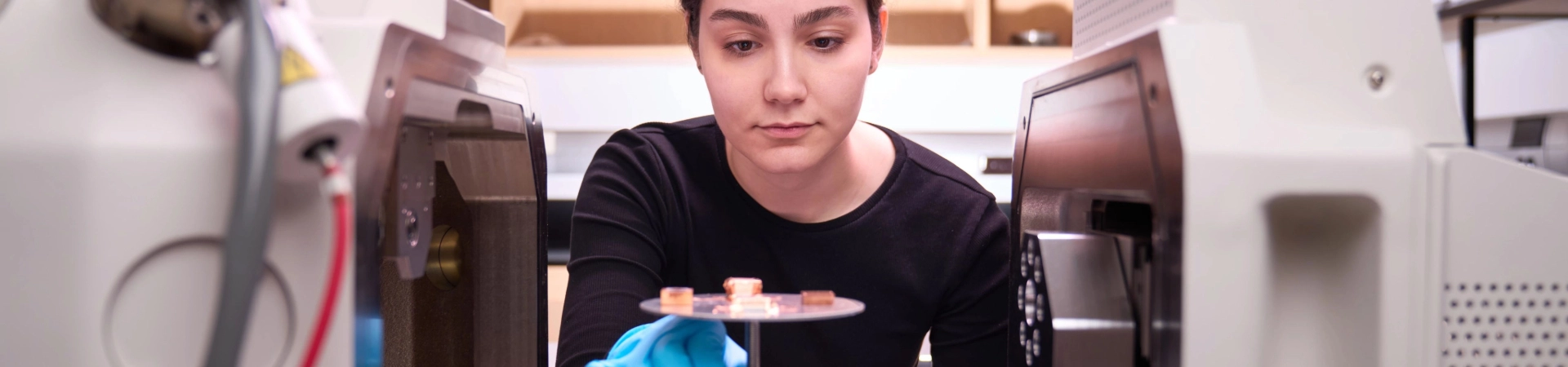 Image of woman staring at a materials on a scientific device