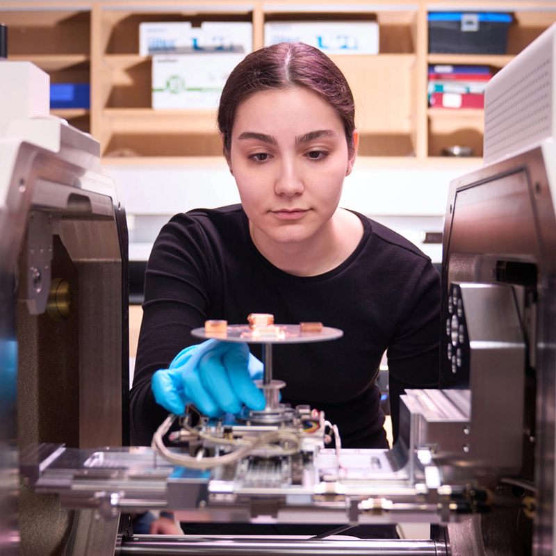 Image of woman staring at a materials on a scientific device