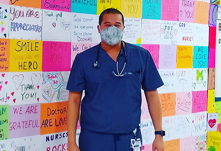 Kwok in front of gratitude wall