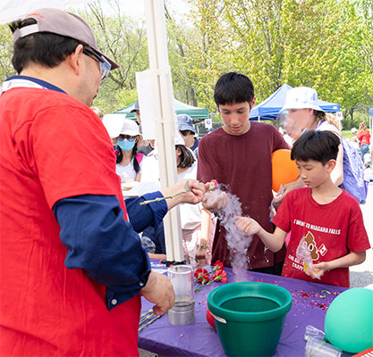 Two children observing the wonders of a flower forzen that has been frozen in liquid nitrogen