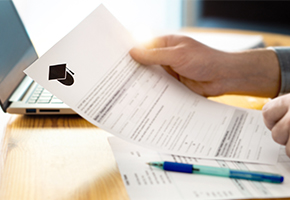 Individual holding application paper at desk