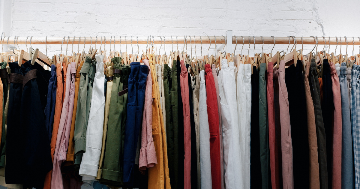 Colourful clothes hanging on a clothing rack. 