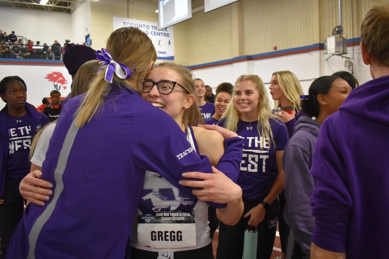 Two girls hugging at a sporting event