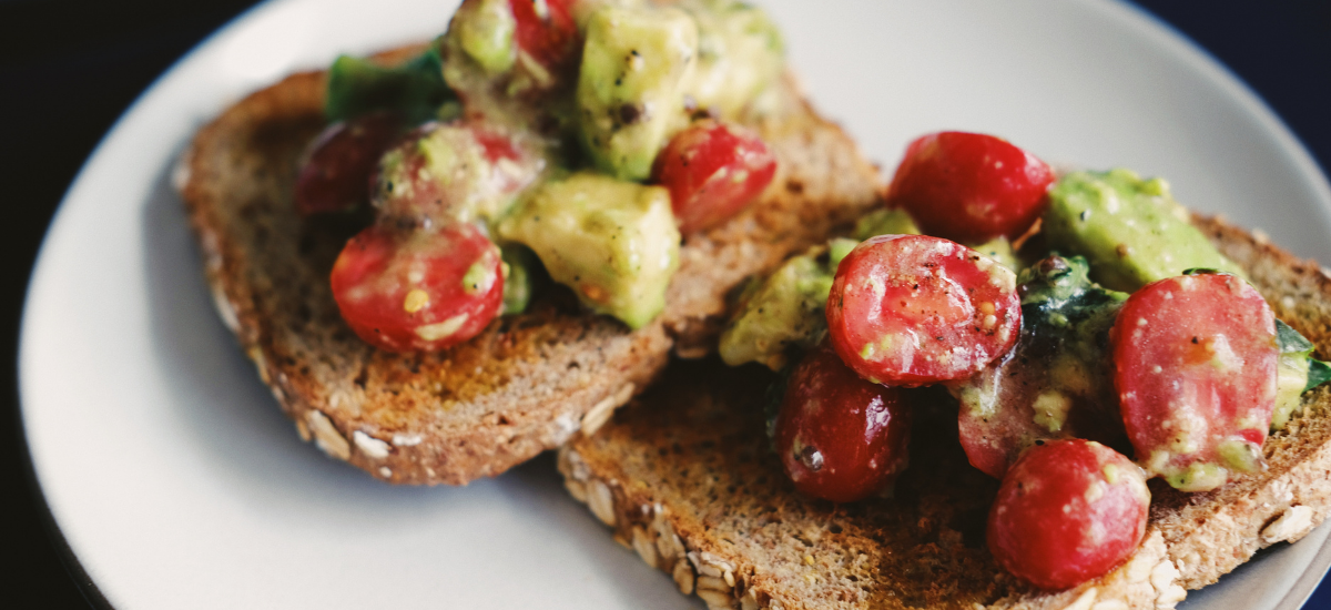 bread covered with avocado, tomato, onion, and seasonings