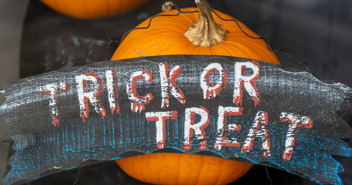 Trick or Treat sign near a pumpkin