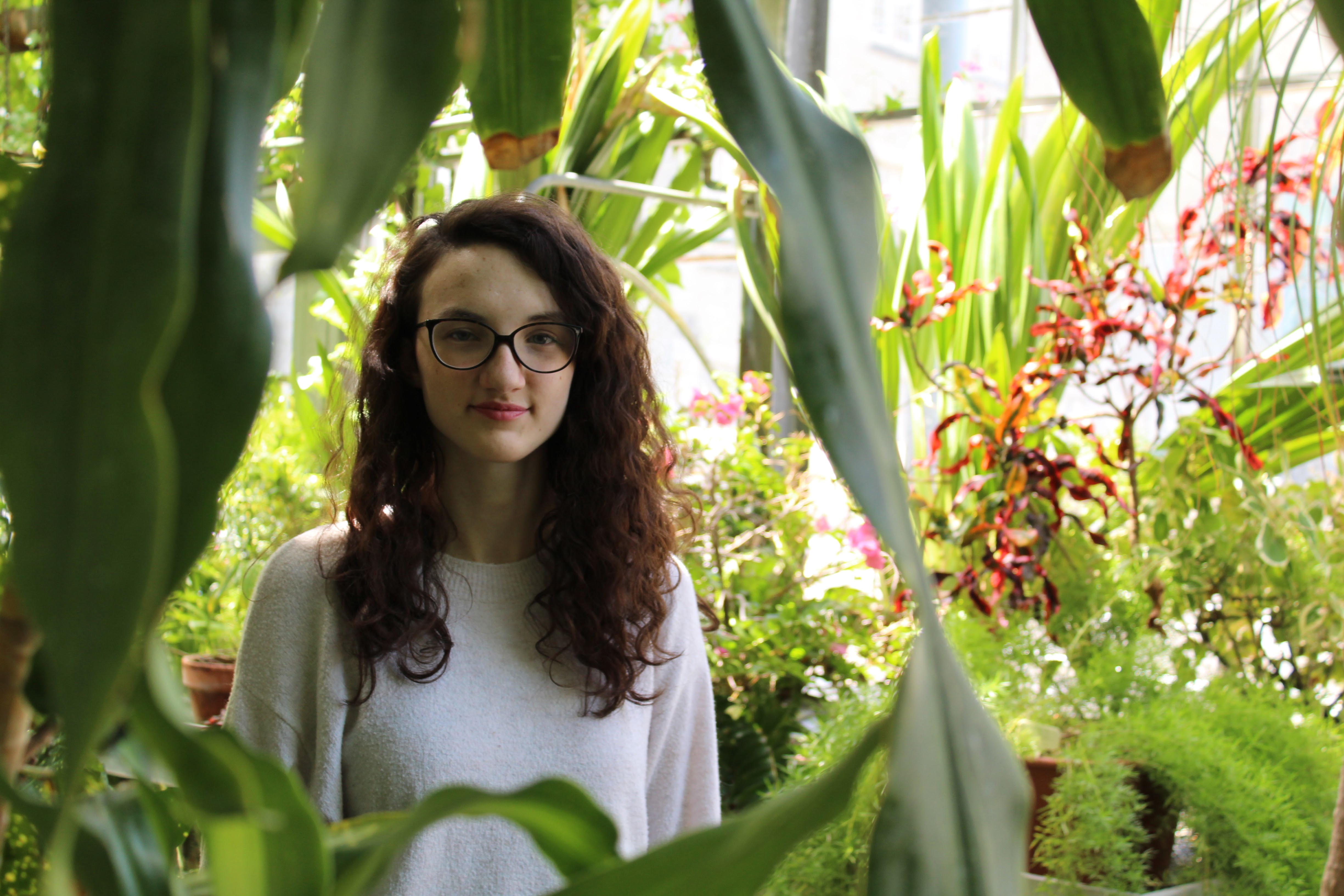 Girl standing in a greenhouse