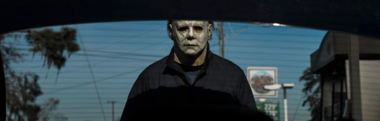 Still image from the movie Halloween of a man staring into the back of a car creepily