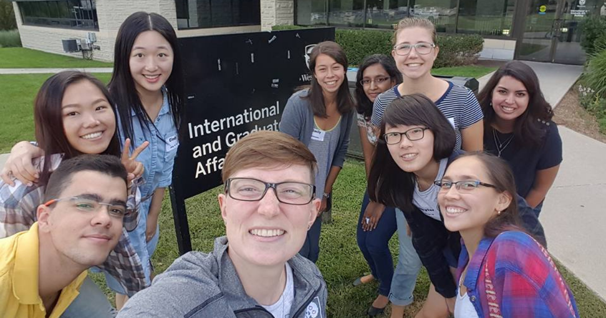 A group of peer guides huddled in a group outside the Western International building on campus 