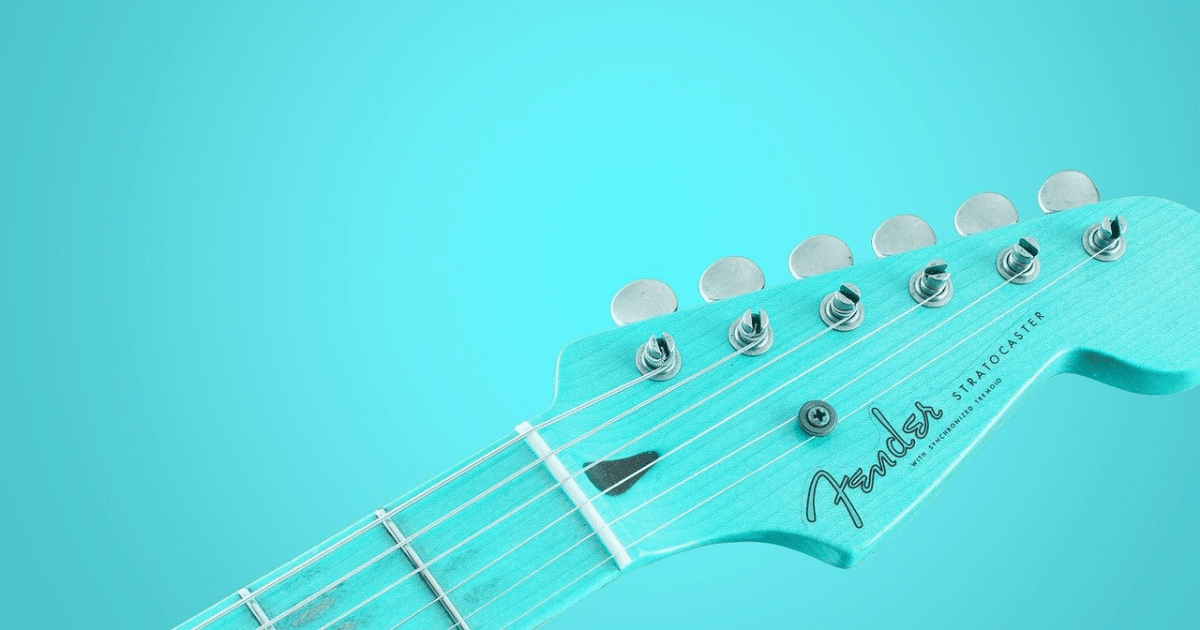 A bright blue guitar on a bright blue background