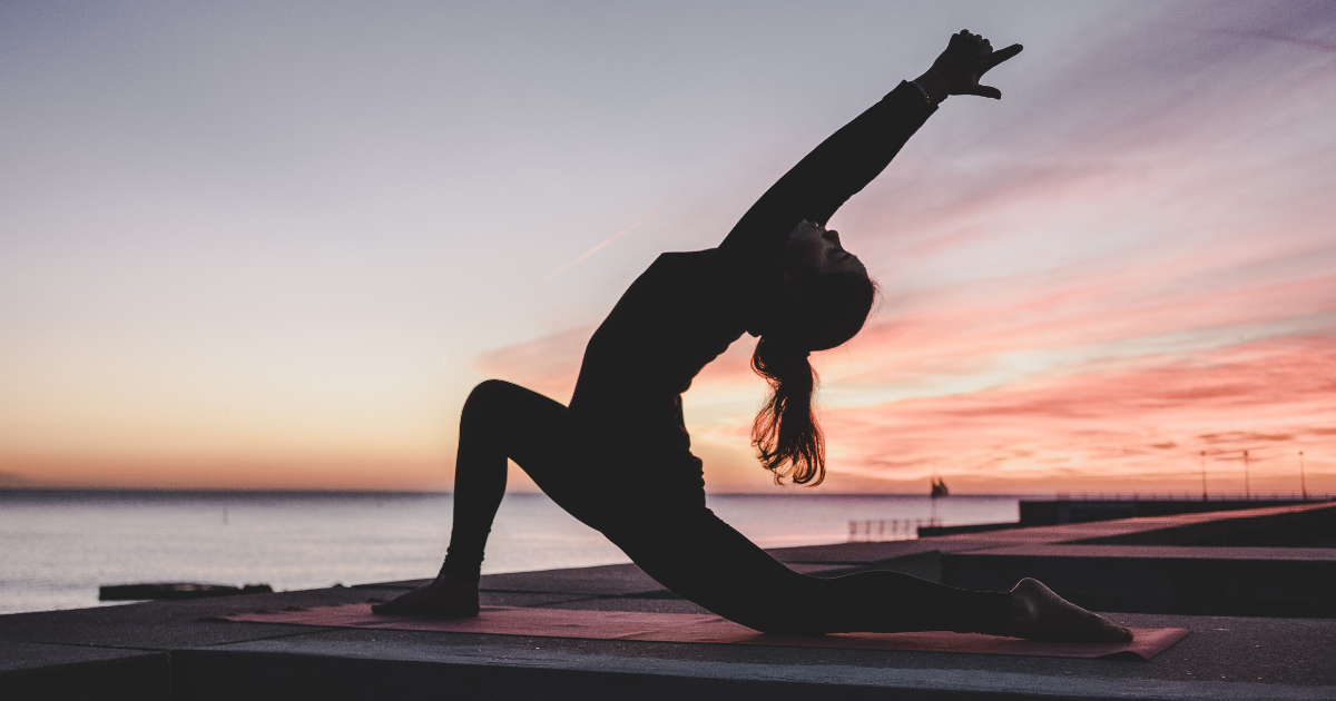 A woman doing yoga in the early morning sun