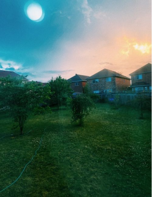 The sky during a summer sunset in a suburban neighbourhood