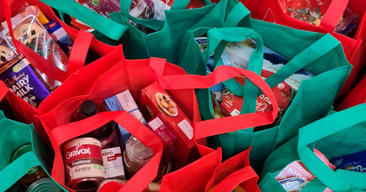 Red and green plastic bags filled with cans of food