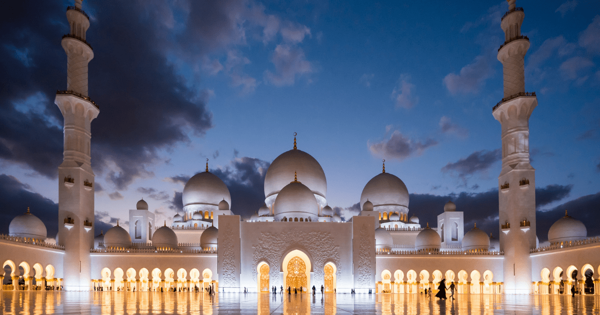 A white mosque under a cloudy night sky