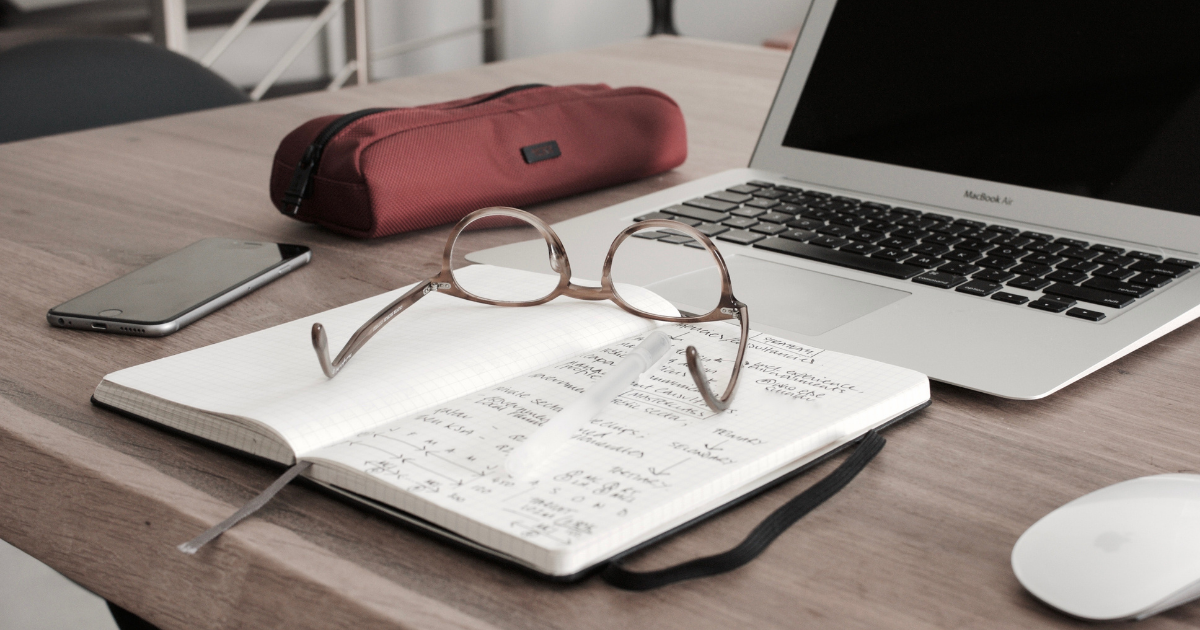 A pair of glasses in front of a computer