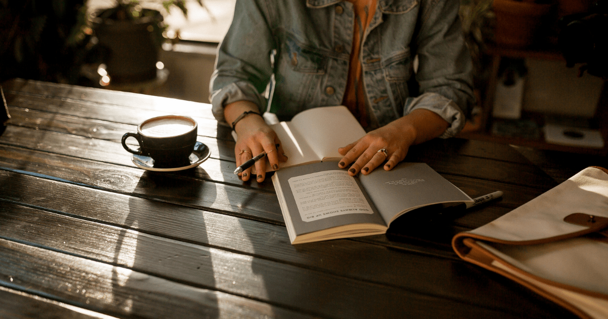 A person sitting at a table writing in a notebook