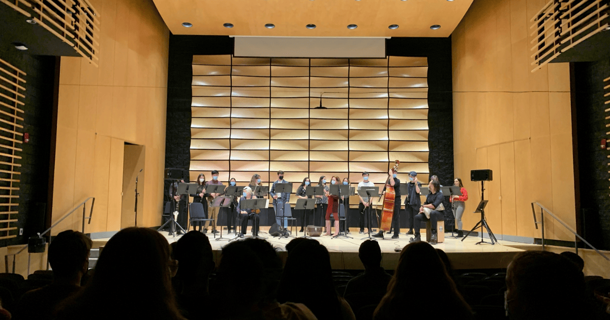 An image from the recital showing some people in the audience and the performers on stage