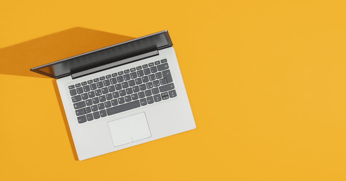 A laptop on a bright yellow desk