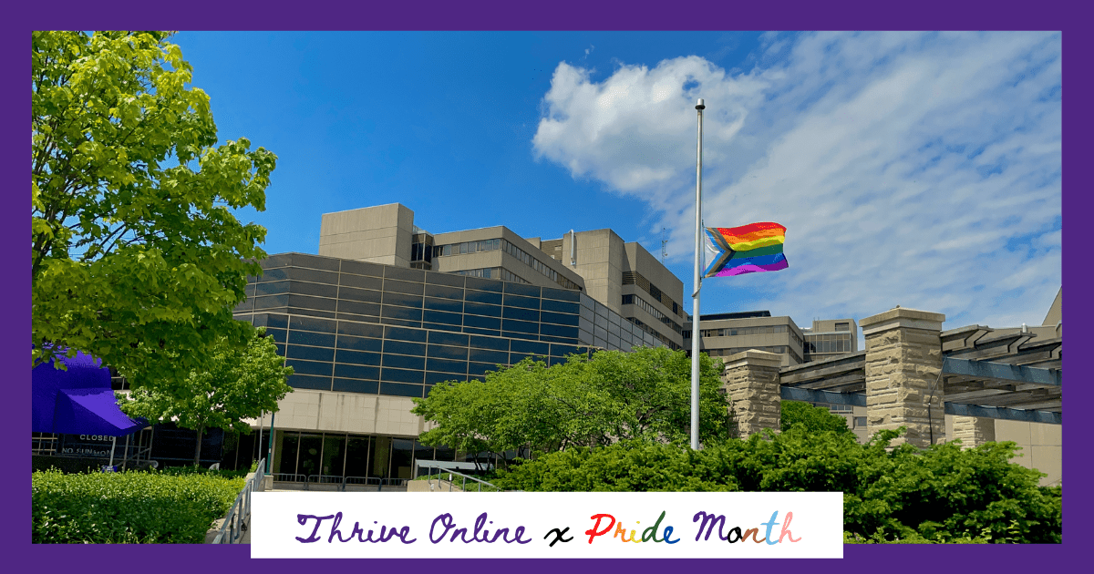A picture of the Pride Progress Flag being flown at half mast on campus.