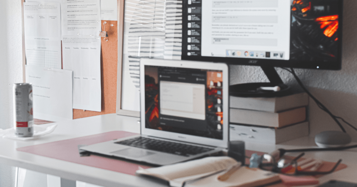 A desk with two computer screens on it