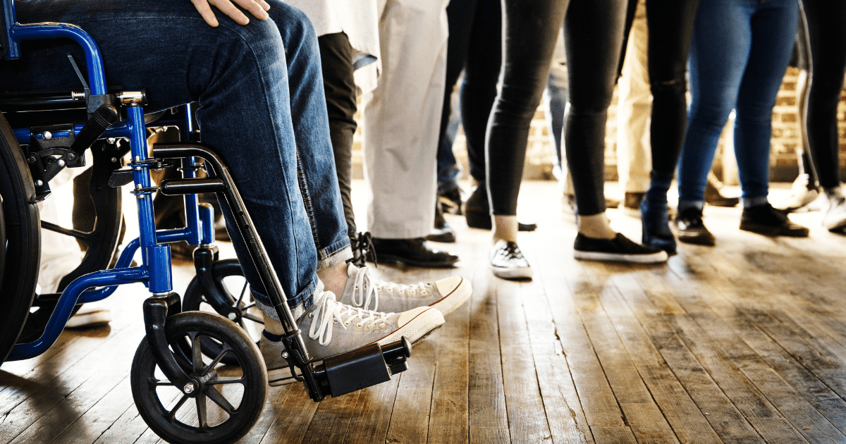 A man in a wheelchair standing in a circle with other people