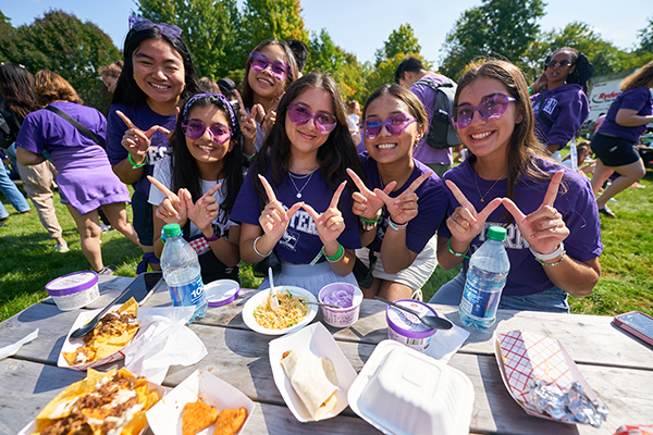 Students eating at a picnic table at the fan festival.