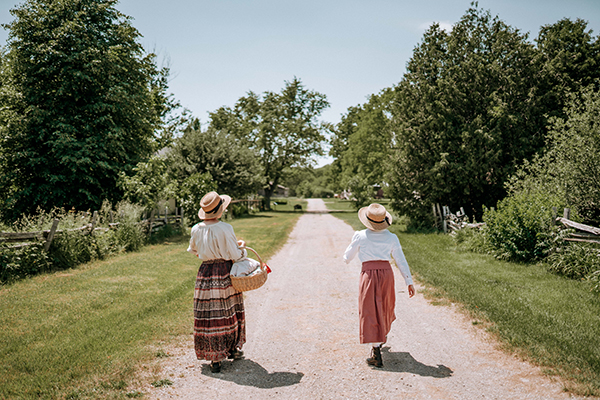 Two people walking in Fanshawe Pioneer Village.