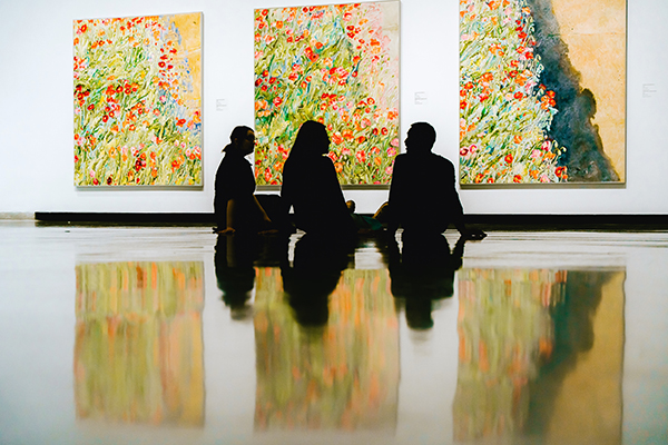 Two people looking at artwork inside Museum London.