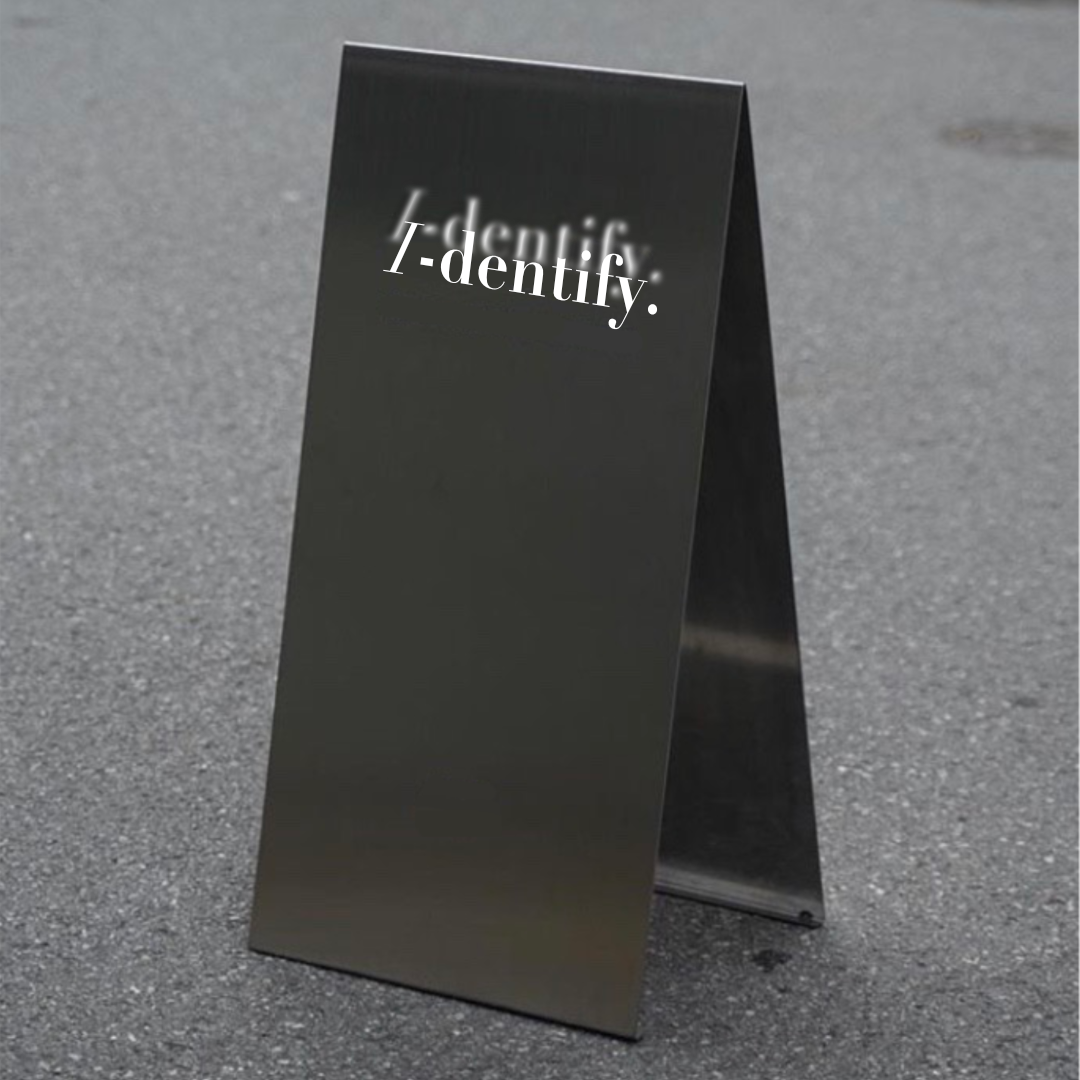 Banner image for Identify exhibition showing a black card folded in half with Identify printed on it