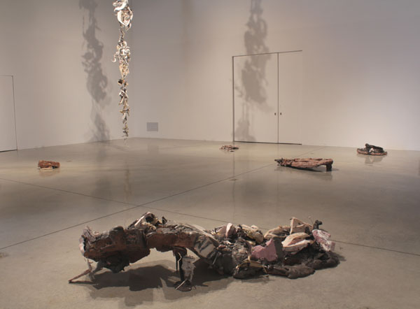 installation view, sculptures on floor and hung from ceiling