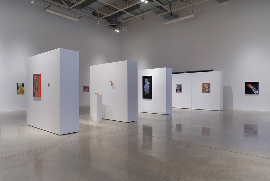 An installation image showing multiple walls stacked in formation with artworks on them