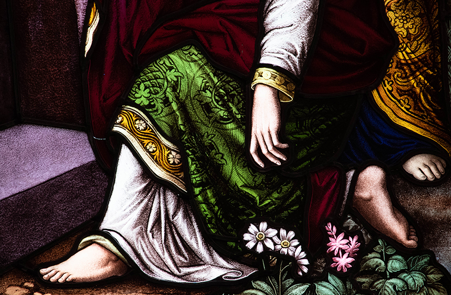 Image of a stained glassed window showing a hand and foot