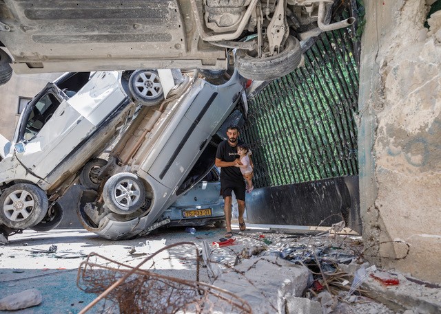 Man carrying child from scene of destruction