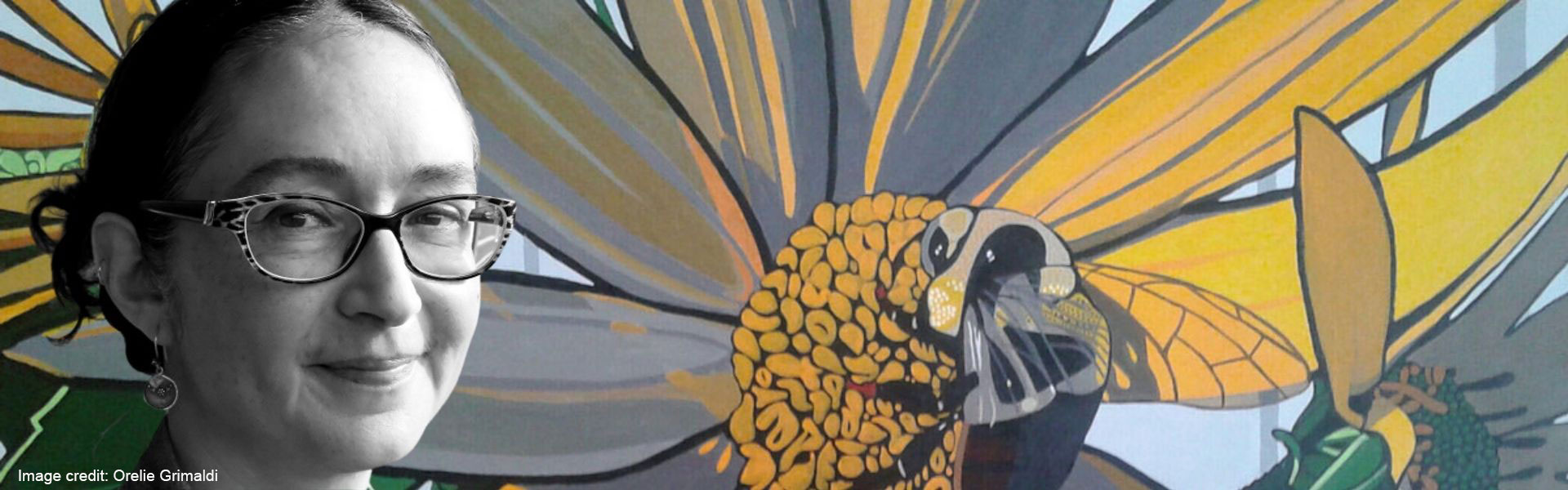 Photo of Indigenous artist with painting of a bee on leaf