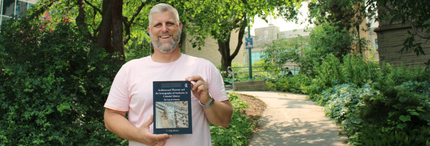 Cody Barteet and his new book in a garden