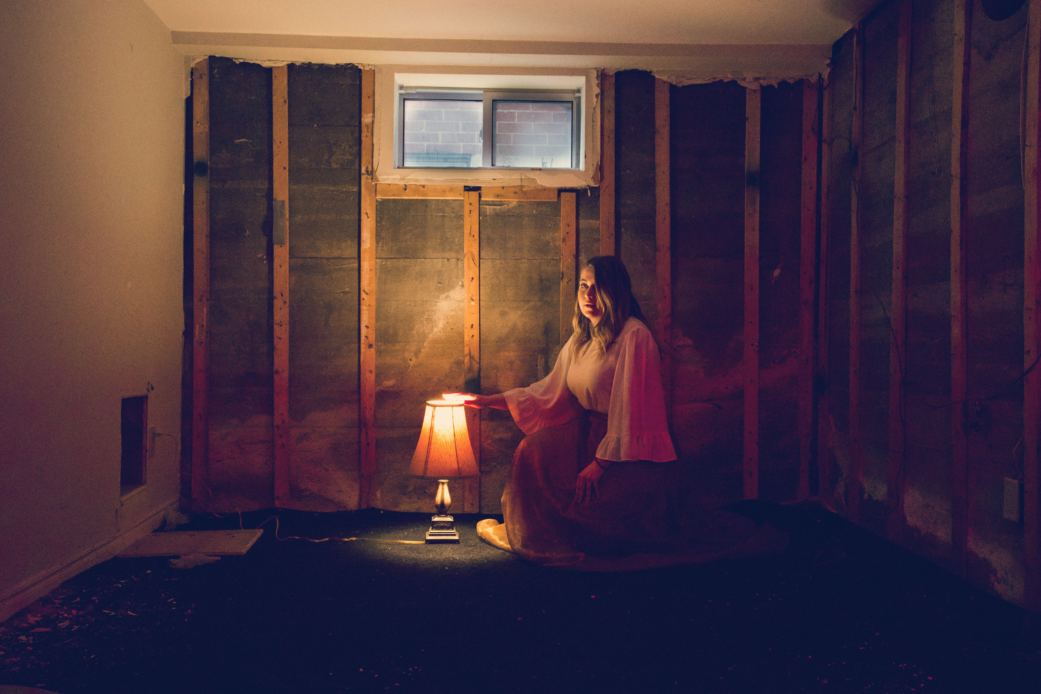 Woman by lamp reading in room in basement