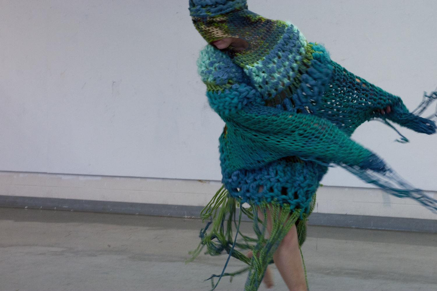 Photo of person moving beneath knitted quilt